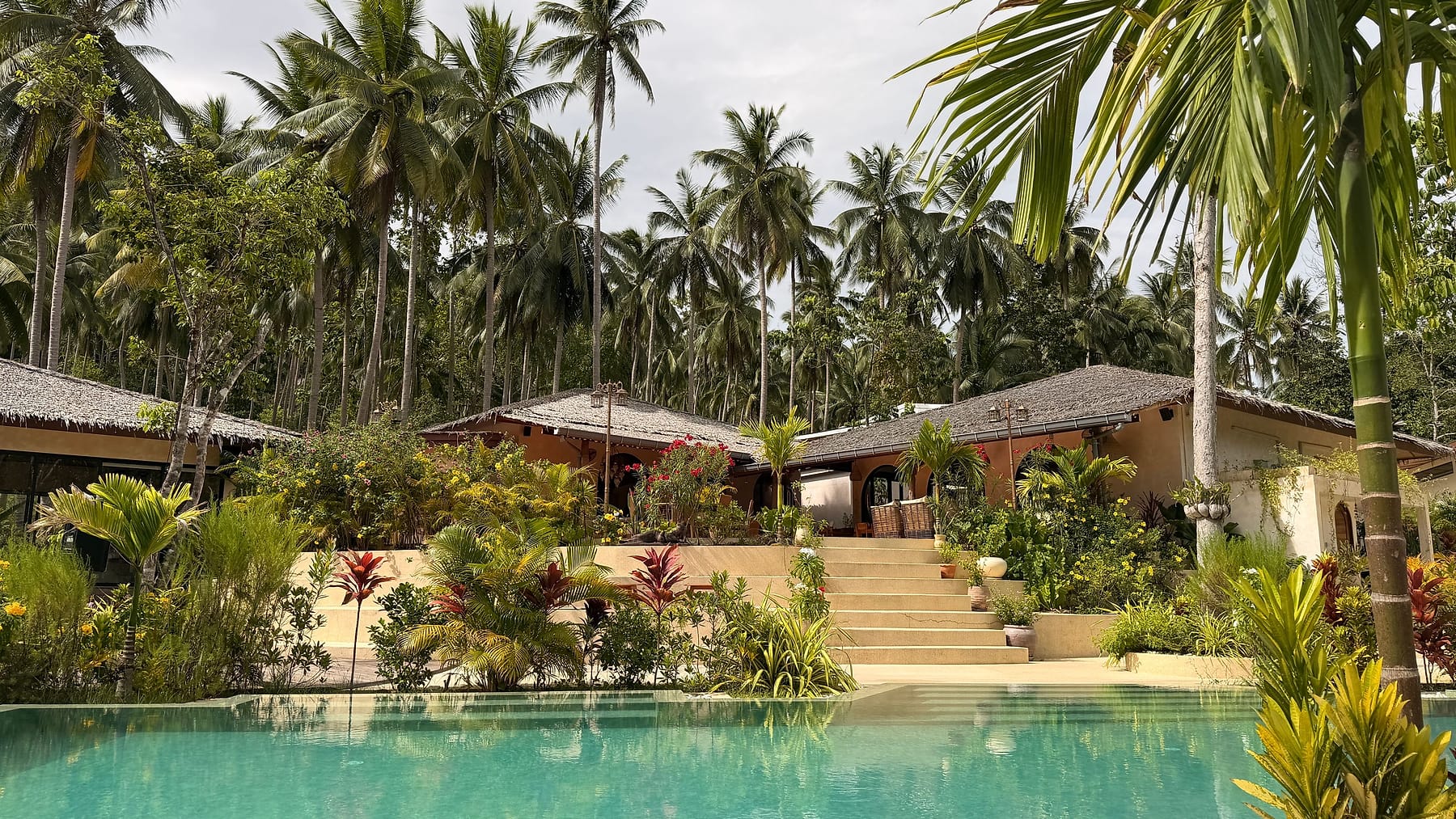 A villa with a pool surrounded by palm trees in southern Thailand