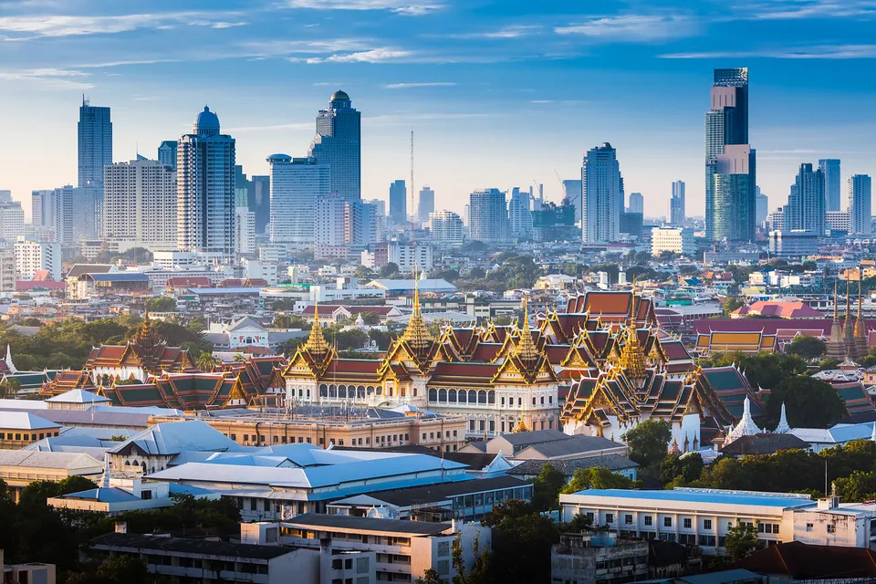 Bangkok skyline rising behind the Grand Palace and historic temple roofs